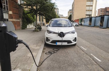 Şehrin caddesinde elektrikli araba şarj ediliyor.