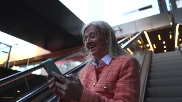 Reife Frau Mit Smartphone Auf Rolltreppe — Stockvideo
