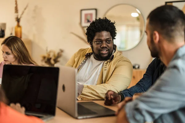 group coworking workers with laptop focus on curvy african american man
