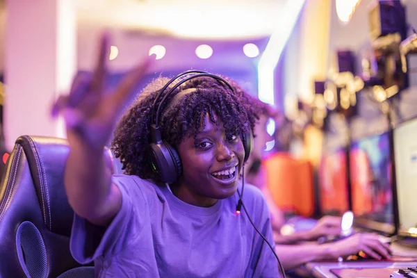 stock image pretty smiling African woman esport game player happy in the battle game with her gaming team, in a video game competition