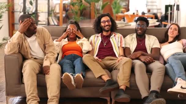 一群多种族的朋友快乐地聚集在沙发上 — 图库视频影像