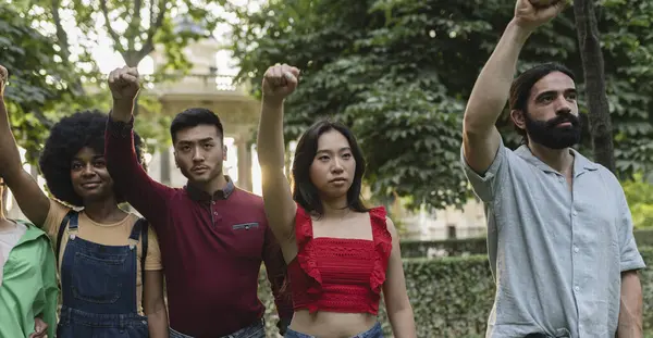 multiracial young people demonstrating with raised fists