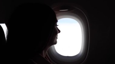 Kadın pencerenin yanındaki uçakta seyahat ediyor - seyahat konsepti -