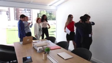 Farklı nesillerden gelen çok ırklı iş arkadaşları yeni meslektaşlarına hoş geldin diyor.