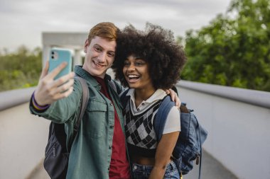 Kameraya gülümseyen çok ırklı çiftin selfie 'si.