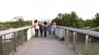 Çok kültürlü bir arkadaş grubu şehir sokaklarında eğleniyor - çeşitli gençler açık havada birlikte gülüyorlar - mutlu yaşam tarzı konsepti