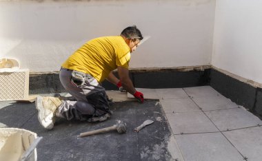 Latin Amerikalı İspanyol işçiler bir terasın döşemesini döşüyorlar.