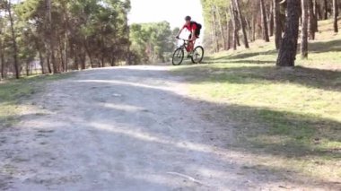 Dağlarda bisiklet süren beyaz erkek bisikletçi ortağını sollar.