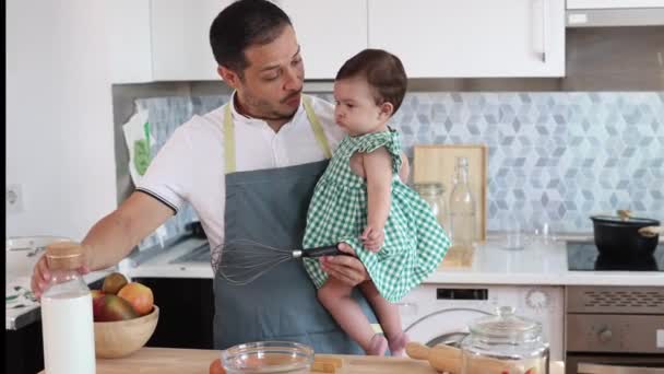 在厨房里 年轻的父亲抱着他的孩子 准备一顿美味的午餐 — 图库视频影像