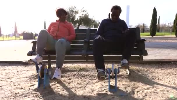 上了年纪的夫妇坐在室外体育馆的长椅上锻炼 — 图库视频影像
