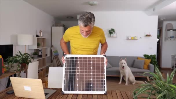Hombre Mayor Casa Sosteniendo Pequeño Panel Solar — Vídeo de stock
