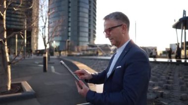 Finans bölgesinde tablet kullanan işadamı