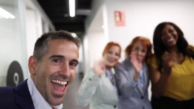 Ofiste selfie - çok ırklı ve çok nesilli iş arkadaşları sosyal medya için akıllı telefonla video kaydediyor
