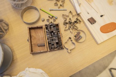 Yukarıdan el yapımı kil harfler ve dizayn için araçlar, kalıplar ve şekiller tablosu üzerinde görünüm