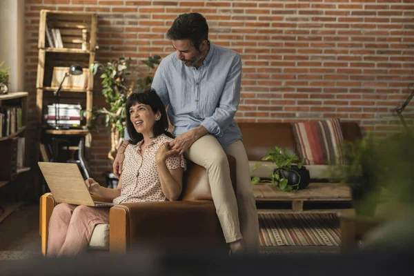 Kanepede oturmuş mali konuları tartışıyorlar, hesaplarını bilgisayarlarıyla kontrol ediyorlar.