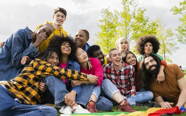 Self portrait of multiracial group of young student friends sitting on campus