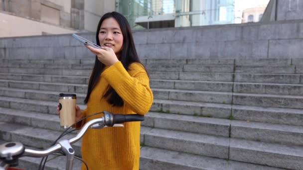 Νεαρή Ασιάτισσα Ποδήλατο Στην Πόλη Πίνοντας Καφέ Και Χρησιμοποιώντας Έξυπνο — Αρχείο Βίντεο