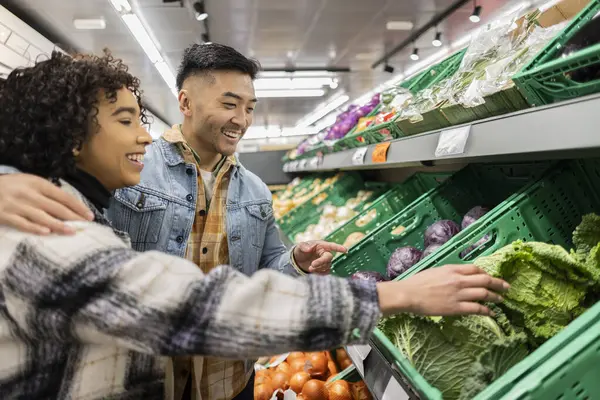 young multiracial couple buying groceries in supermarket