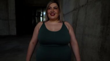 Kavisli sporcu kadın dışarıda mutlu bir şekilde koşuyor.