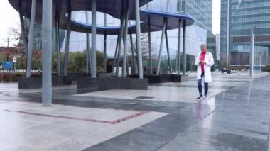 Hastanenin dışında koşan hemşire - acil durum. Doktor boş zamanlarında, cep telefonuna bakarak yürüyordu ve aniden acil bir durum çıktı.