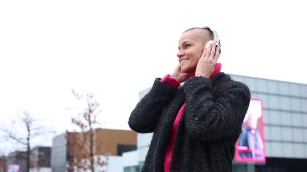 Kulaklıklı Traşlı Kadın Şehirde Müzik Dinliyor — Stok video