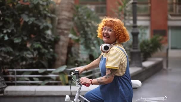 庭の自転車にタトゥーが付いている赤毛の成熟した女性 — ストック動画