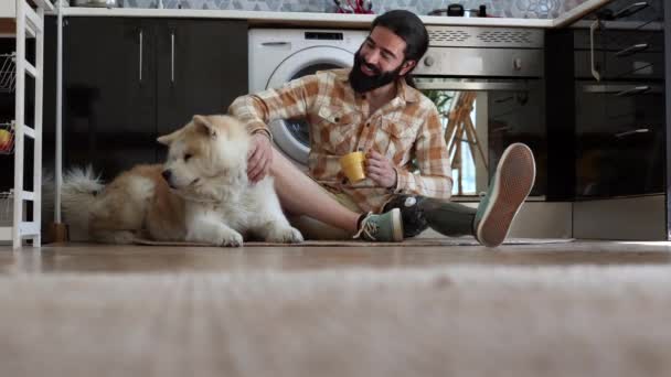 Hombre Apartamento Sentado Suelo Junto Perro Cocina Beber Café Discapacidad — Vídeo de stock