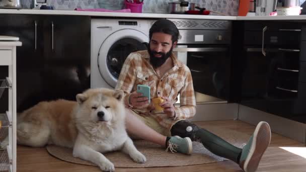 Мужчина Бионической Ногой Ампутации Своей Квартире Одинокий Собакой Смотрящей Социальные — стоковое видео