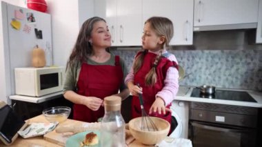 Büyükanne ve torun evde mutfakta yemek pişiriyor, pasta hazırlıyorlar.