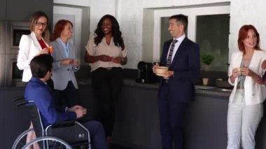 Modern ofis, iş arkadaşları kahve içiyor ve konuşuyor.