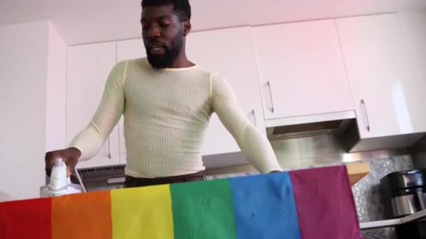 Человек Внимательно Гладит Разноцветный Радужный Флаг Готовится Торжествам Гордости Дома — стоковое видео
