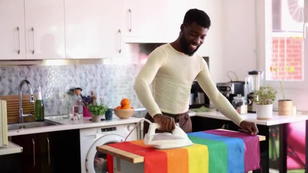 Neşeli Gökkuşağı Bayrağını Ütüleyen Gülümseyen Adam Lgbt Güneşli Mutfakta Ütü — Stok video