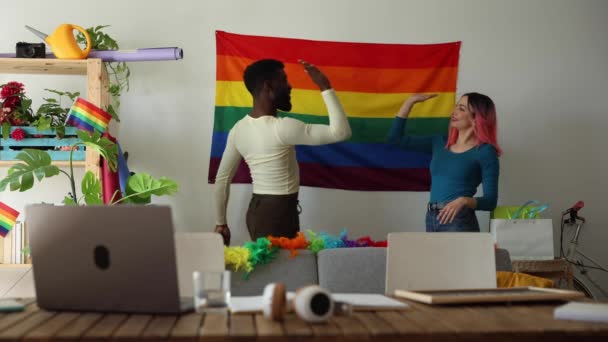 Веселая Пара Вешает Радужный Флаг Гордости Гостиной Празднуя Разнообразие — стоковое видео