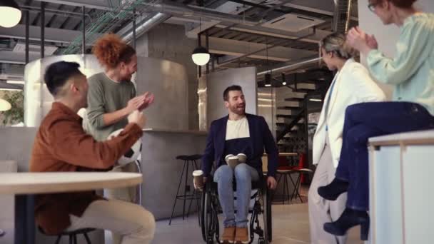 多样化的团队与坐在轮椅上的同事一起享受轻松的咖啡休息时间 — 图库视频影像
