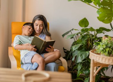 Bir anne ve oğul kitap okurken huzurlu bir anı paylaşırlar..