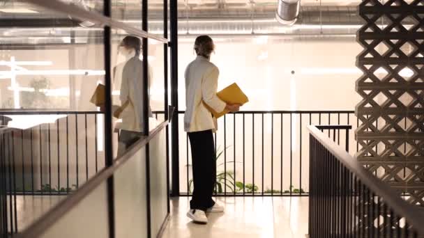 オフィスビルの近代的な階段で会話する黄色いフォルダを持つ2人の専門家 — ストック動画
