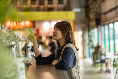 Nişanlı Genç Kadın Vibrant Kafe 'den sipariş veriyor.