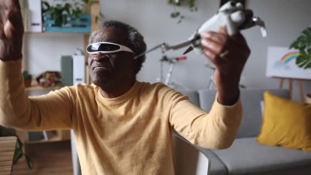 内部のドローンを操縦する3Dメガネの熟練した上級男性 自宅での技術の楽しみ — ストック動画