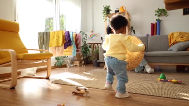 在一间阳光灿烂的客厅里 一个蹒跚学步的孩子朝着妈妈张开的胳膊迈出了快乐的第一步 — 图库视频影像