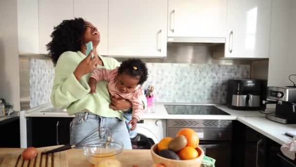 Зайнята Молода Мама Готує Їжу Тримаючи Допитливого Малюка Багатозадачність Вдома — стокове відео