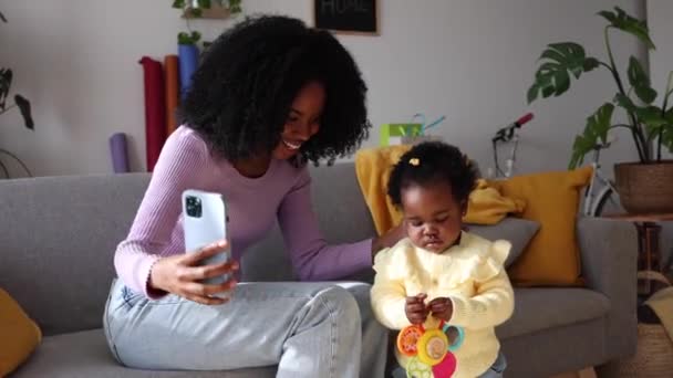 一位快乐的母亲带着专注于技术的幼儿抓住了一个瞬间 — 图库视频影像