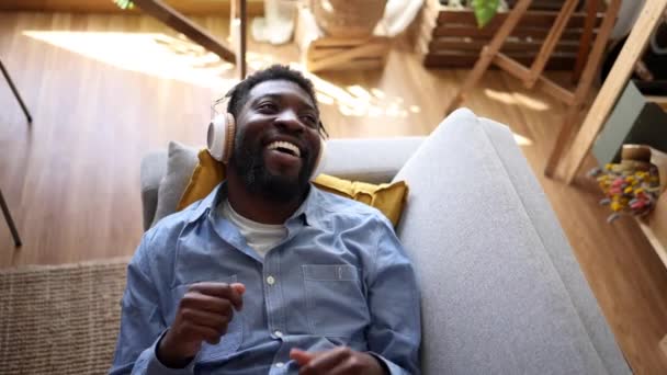 Африканський Американець Яскравою Посмішкою Носить Навушники Насолоджуючись Гумористичним Подкастом Або — стокове відео
