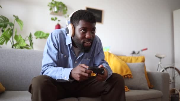 Afroameričan Při Hraní Doma Široce Usmívá Používá Bezdrátový Ovladač Sluchátka — Stock video