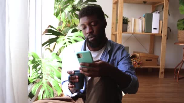 Jovem Africano Triste Olha Para Tela Seu Smartphone Reagindo Más — Vídeo de Stock