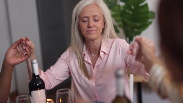 ソーシャルディナーで落ち着いた瞬間に目を閉じた成熟した女性 夕食会での平和的な反省の女性 — ストック動画