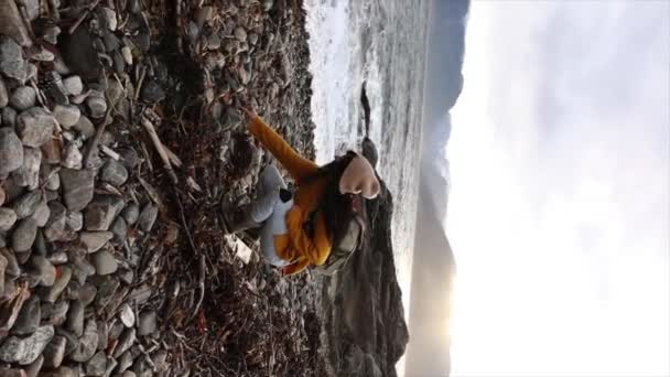 Молодая Женщина Жёлтом Свитере Задумчиво Стоит Галечном Пляже Закат Солнца — стоковое видео