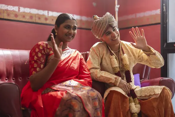 stock image Young individuals in Indian traditional wear sharing a playful greeting, radiating cultural joy.