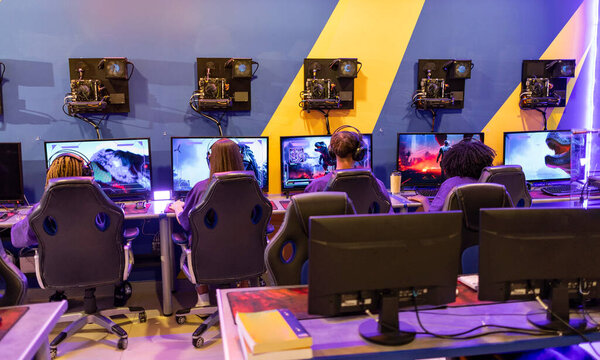 Группа геймеров глубоко погружена в соревновательную битву видеоигр на игорном мероприятии.