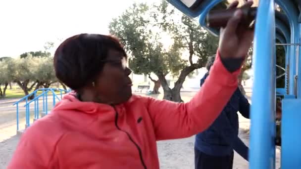 안경을 여성은 올리브 나무의 그늘에서 피트니스 장비를 그녀의 파트너 연습으로 — 비디오
