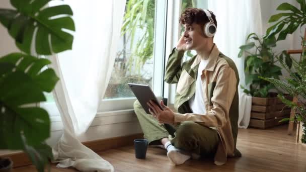 Ein Nachdenklicher Junger Mann Sitzt Fenster Gedankenverloren Mit Musik Und — Stockvideo